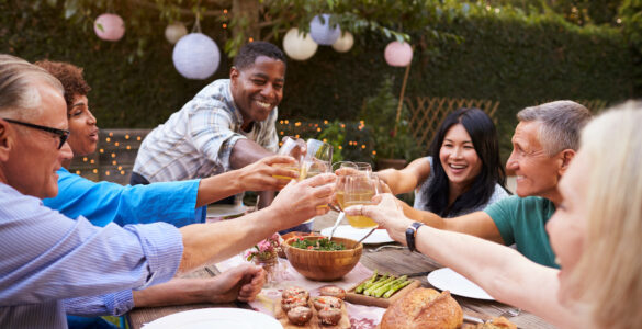 Group of friends toasting at a garden party. Mood boosters for mental health on Tonic