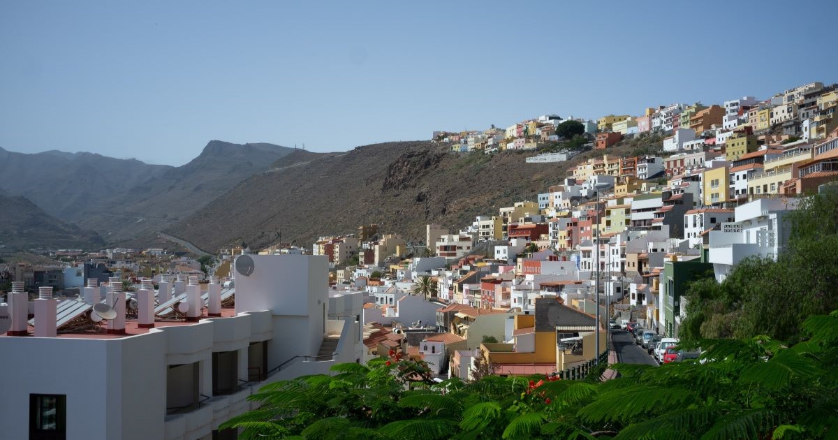 Image of La Gomera from overhead, showing lots of square, white and colourful buildings on a hillside.