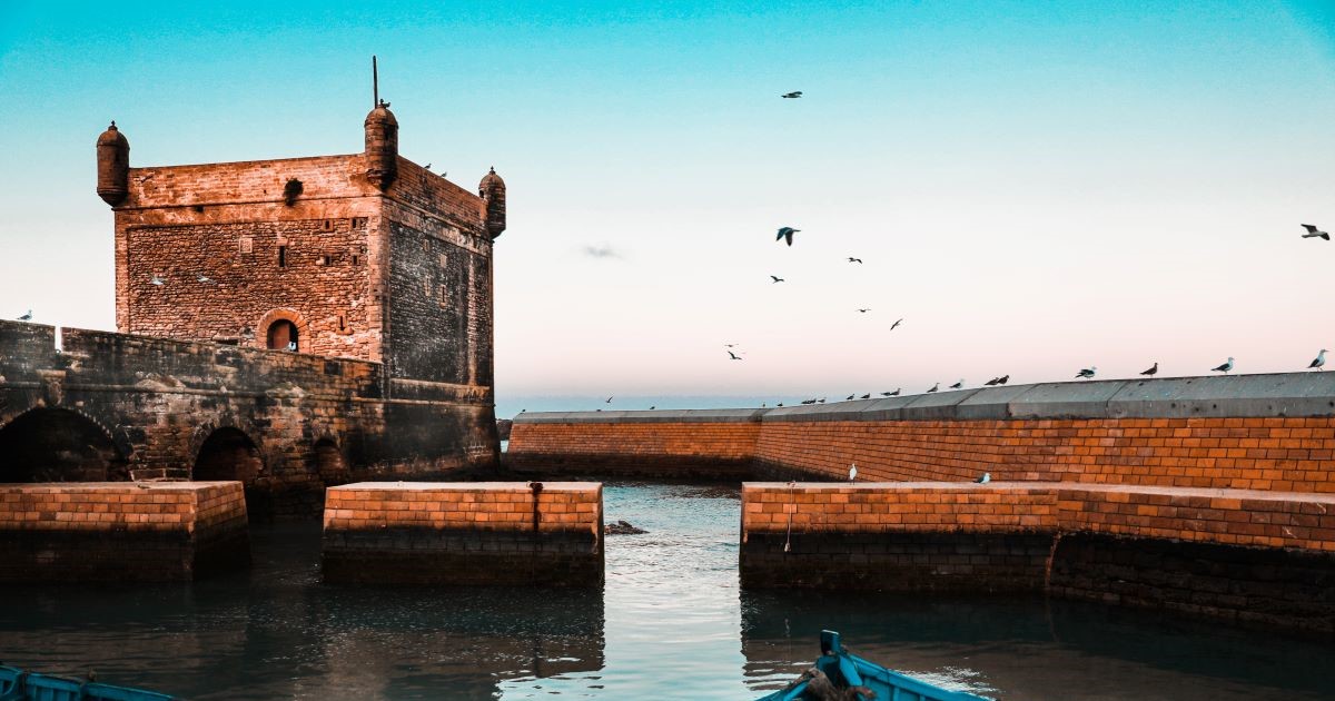 An image of Essaouira, showing a castle-like structure with an attached wall in the water.