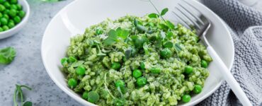 Tasty looking green pea risotto in a nice white bowl
